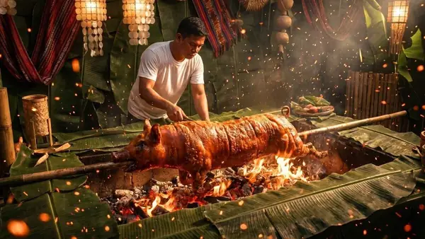 A whole Cebu lechon turning on the spit over an open fire, banana leaves behind
